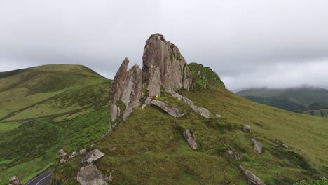 Fotograf-In-Gelber-Jacke-Am-Großen-Felsen-Mitten-In-Der-Natur-Auf-Den-Azoren-–-Drohnenaufnahme