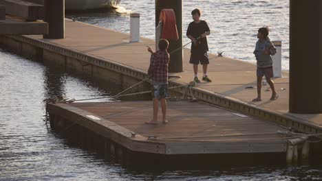 Three-kids-fishing-on-pontoon-on-the-harbour-Newcastle