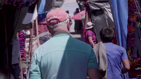 Anciano-Gringo-Caminando-Por-El-Mercado-Chichi-En-Guatemala,-Durante-El-Día