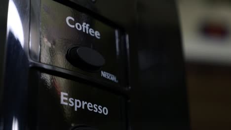 Un-Dedo-Presiona-El-Botón-De-Café-En-Un-Vendedor-De-Máquinas-De-Café-Nescafè-Varias-Veces.