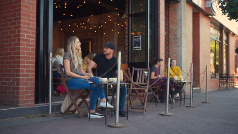 Ein-Glückliches-Paar-Auf-Der-Terrasse-Eines-Cafés-Unterhält-Sich-Miteinander