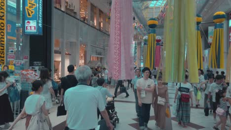 People-in-arcade-walking-through-decorative-paper-streamers-during-Tanabata-festival