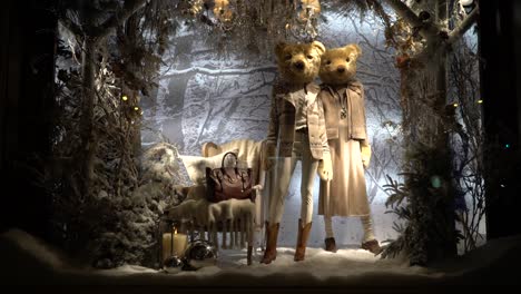 Eine-Teure-Und-Luxuriös-Dekorierte-Vitrine-Mit-Designerkleidung,-Winterdekoration-Und-Zwei-Bären-Als-Schaufensterpuppen