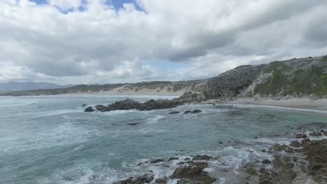 Luftaufnahme-Von-Touristen-Aus-Dem-Inneren-Der-Klipgat-Höhle,-Die-Den-Blick-Auf-Das-Meer-Und-Den-Strand-Im-Naturschutzgebiet-Walker-Bay-In-Südafrika-Freigibt