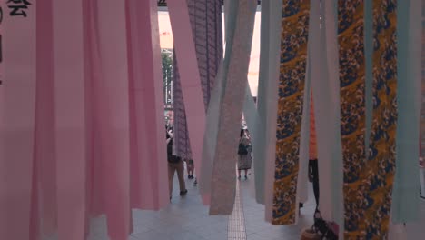 People-in-arcade-walking-through-decorative-paper-streamers-during-Tanabata-festival