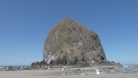 Gente-De-Vacaciones-En-Haystack-Rock-En-Un-Día-Claro-Y-Soleado