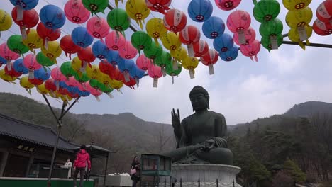 Menschen-Gehen-An-Einem-Großen-Bronzenen-Buddha-Vorbei-Und-Bringen-Opfergaben-Dar