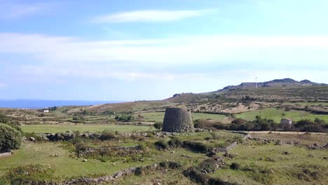 Sardinia,-Drone-Aerial-shot-towards-a-Nuraghe-a-monolith-prehistorical-construction-in-the-island-of-Sardinia-in-Italy