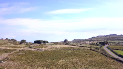 Sardinia,-Drone-Aerial-shot-towards-a-Nuraghe-a-monolith-prehistorical-construction-in-the-island-of-Sardinia-in-Italy