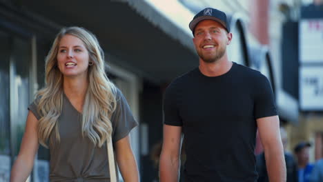 Closeup-of-Couple-in-Mid-Twenties-Laughing-Together-as-They-Walk-Down-Whyte-ave-in-Edmonton,-Alberta