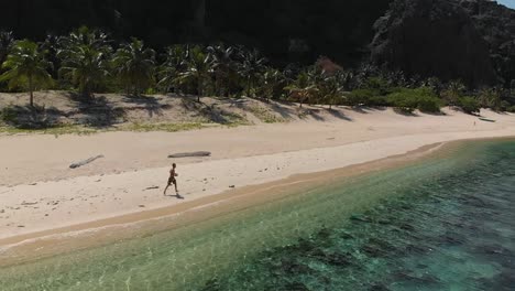 Zeitlupen-Drohnenaufnahme-Eines-Mannes-Beim-Training-An-Einem-Tropischen-Strand,-In-Der-Nähe-Von-Klarem,-Türkisfarbenem-Wasser,-Auf-Black-Island,-Auf-Den-Philippinen,-Asien