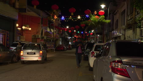 Persona-Caminando-Por-Una-Calle-Concurrida-Por-La-Noche,-Pequeña-India,-Luces-De-Linterna,-Malasia