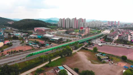 Aerial-gentle-rise-up-pedestal-towards-city-and-highway-bridge-intersection