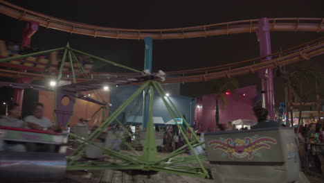 Gente-Montando-Las-Atracciones-Y-La-Montaña-Rusa-En-El-Parque-Pacífico-De-Santa-Mónica-Por-La-Noche-Durante-El-Verano-En-Cámara-Lenta