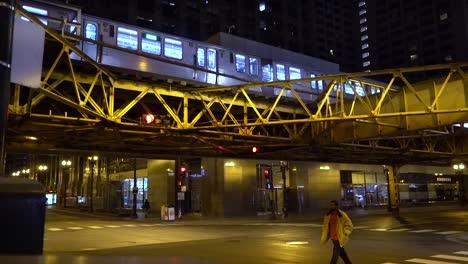 The-train-is-driving-on-the-railway-while-pedestrians-are-crossing-the-road-at-the-night