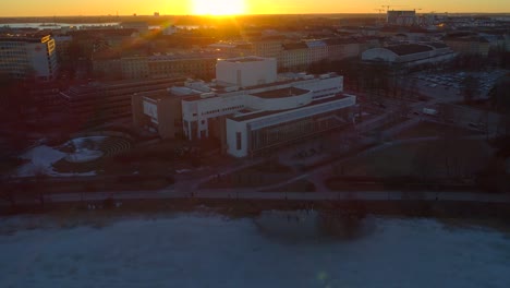 Helsinki-opera-house,-aerial,-reverse,-drone-shot,-away-from-Suomen-Kansallisooppera,-on-a-sunny,-spring-evening,-in-Helsingfors,-Uusimaa,-Finland