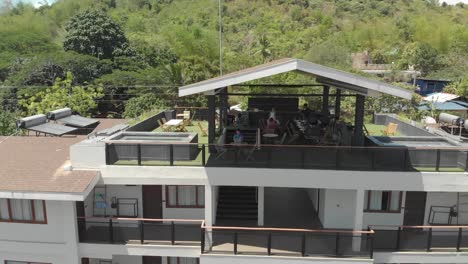 Un-Dron-Aéreo-Disparó-Desde-Un-Hombre-Que-Trabajaba-En-Su-Computadora-Portátil,-Revelando-Una-Ciudad-Tropical,-En-La-Isla-De-Coron,-En-Filipinas,-Asia.