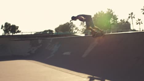 Follow-shot-of-male-in-baseball-cap-riding-around-skate-park-bowl-fluid-motion