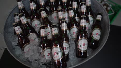 Clip-En-Cámara-Lenta-De-Botellas-De-Cerveza-Frías-En-Una-Tina-De-Metal-Llena-De-Hielo