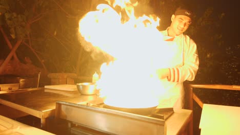 Un-Chef-Preparando-Comida-En-La-Cocina-Al-Aire-Libre-De-Un-Restaurante