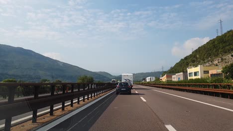 Driving-on-a-highway-in-the-region-of-Trentino-Alto-Adige,-in-Northern-Italy-on-a-partially-cloudy-autumn-day