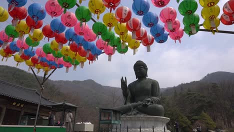 Menschen-Gehen-An-Einem-Großen-Bronzenen-Buddha-Vorbei-Und-Bringen-Opfergaben-Dar