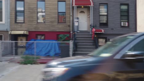 Pov-shot-from-car-driving-in-streets-of-New-York-with-american-neighborhood-in-sunlight