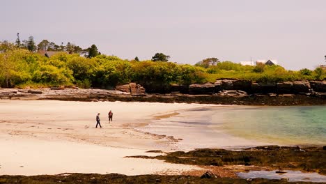 Ein-Kleiner-Junge-Führt-Einen-Mann,-Der-Ein-Boot-Rückwärts-Ins-Wasser-Im-Kettle-Cove-State-Park-Fährt