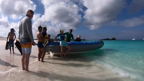 Un-Pasajero-Se-Prepara-Para-Abordar-El-Barco-En-Una-Playa-De-Arena-Blanca-Y-Aguas-Turquesas-De-Las-Islas-Galápagos