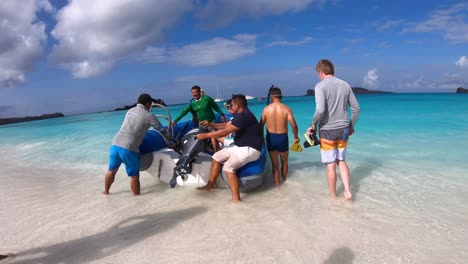 Two-men-are-holding-the-boat-while-two-tourists-are-getting-ready-to-board-it