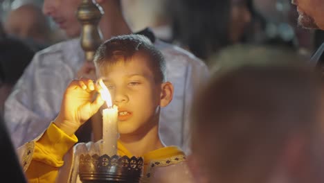 Un-Joven-Vestido-Con-Túnicas-Del-Desfile-Nocturno-De-Pascua-Juega-Con-Su-Vela-Encendida