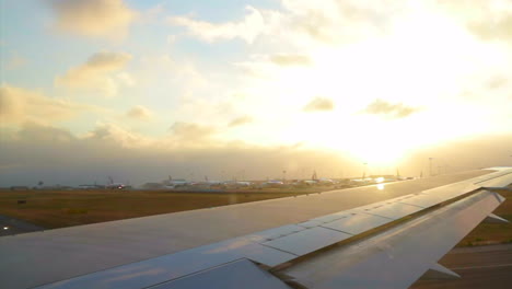 Carril-Preparándose-Para-Despegar-En-El-Aeropuerto-De-Lisboa-Con-El-Sol-Al-Fondo