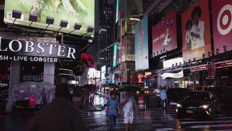 La-Concurrida-Avenida-Broadway-De-Nueva-York-Durante-La-Noche-Con-Luces-Brillantes-Y-Vallas-Publicitarias,-Justo-Después-De-Que-Haya-Pasado-Una-Tormenta,-La-Gente-Cruza-La-Calle