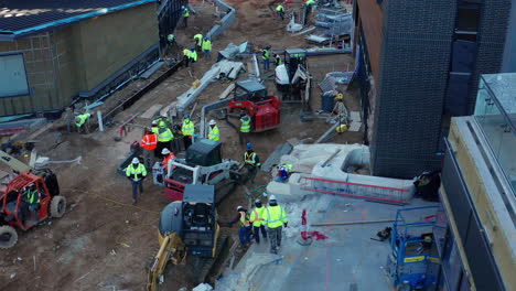 Workers-on-a-large-commercial-jobsite-viewed-from-moving-drone