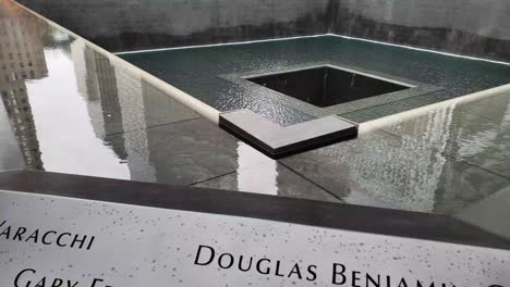 Panning-shot-of-the-twin-towers-fountain-memorial-in-New-York,-Manhattan-with-the-names-of-the-victims