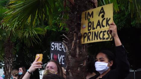 Una-Hermosa-Joven-Sostiene-Un-Cartel-De-Papel-Amarillo-Durante-Una-Protesta-Contra-El-Racismo-En-Europa.