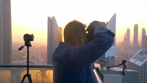 Fotógrafo-Masculino-Tomando-Fotografías-Del-Paisaje-Urbano-De-Dubai-En-La-Luz-Del-Sol-De-La-Hora-Dorada.