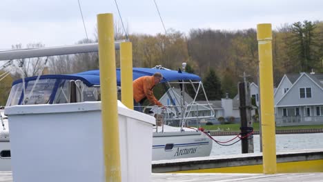 Macho-Adulto-En-Barco-Levantando-Una-Cuerda-En-El-Puerto-Deportivo-Del-Lago-Michigan.