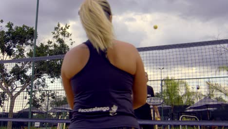 Woman-playing-beach-tennis-at-sunset-in-slow-motion