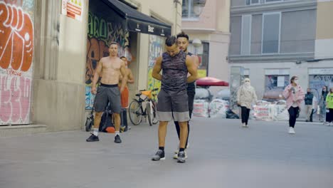 Street-performers-performing-spectacular-athletic-tricks-during-live-street-show-in-front-of-crowd-of-tourists-sitting-at-bars-and-restaurants-in-Barcelona,-Spain-during-sunset-on-warm-evening