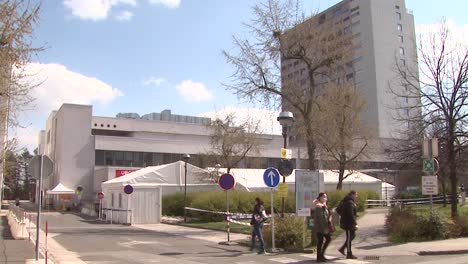 People-with-masks-walking-in-front-of-emergency-hospital-tents