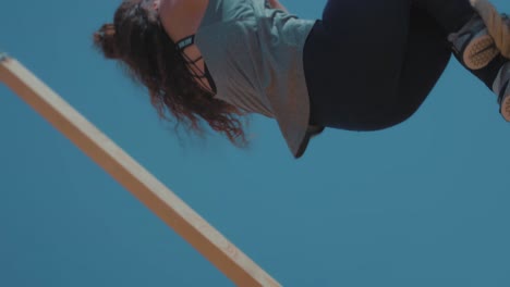 A-female-Athlete-hardly-climbing-A-Rope-bar-by-the-beach---Slow-Motion