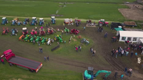 Vista-Aérea-De-Una-Reunión-De-Tractores-En-Wilsveen,-Países-Bajos,-Panorámica-De-Derecha-A-Izquierda-Sobre-Campos-Verdes-Con-Gente-Caminando