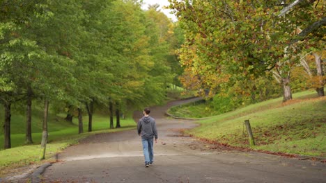 Un-Joven-Caucásico-Con-Capucha-Gris-Camina-Solo-Por-Una-Carretera-Vacía