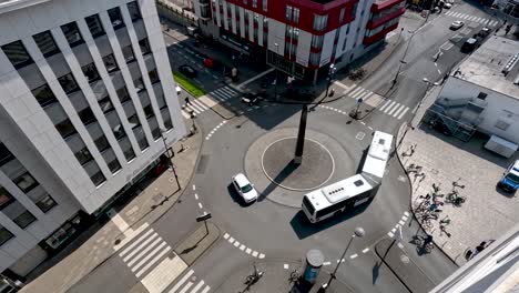 Hoher-Blick-Von-Oben-Auf-Den-Kurvenreichen-Bus,-Der-Am-Kreisverkehr-In-Köln-Um-Den-Obelisken-Des-Tutanchamun-Herumfährt