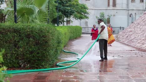 Un-Hombre-Vertiendo-Agua-En-Un-árbol-En-El-Parque-Por-La-Noche-Desde-Un-ángulo-Plano.-El-Video-Se-Toma-En-Jodhpur-Rajasthan,-India,-El-5-De-Mayo-De-2023.