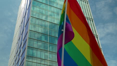 Bandera-Simbólica-Lgbtq-Ondeada-Durante-La-Marcha-Por-La-Libertad-En-Varsovia,-Polonia,-Contra-El-Edificio-De-Oficinas