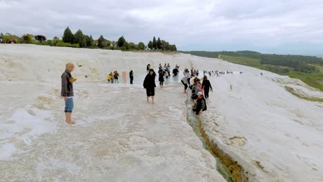 Crowds-of-visitors-to-Pamukkale-walk-barefoot-in-natural-hot-springs-attraction