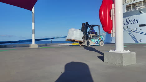 Una-Robusta-Carretilla-Elevadora-Transporta-Con-Destreza-Pesadas-Bolsas-De-Hielo-A-Través-De-Un-Muelle,-Asegurando-Un-Suministro-Constante-De-Refrescos-En-La-Isla