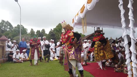 Topeng-Masked-Dance-Performance-in-Balinese-Hindu-Temple-Ceremony,-Traditional-Art-form-Ritual-in-Colorful-Festival-Clothes,-Tourists-observe-the-Show